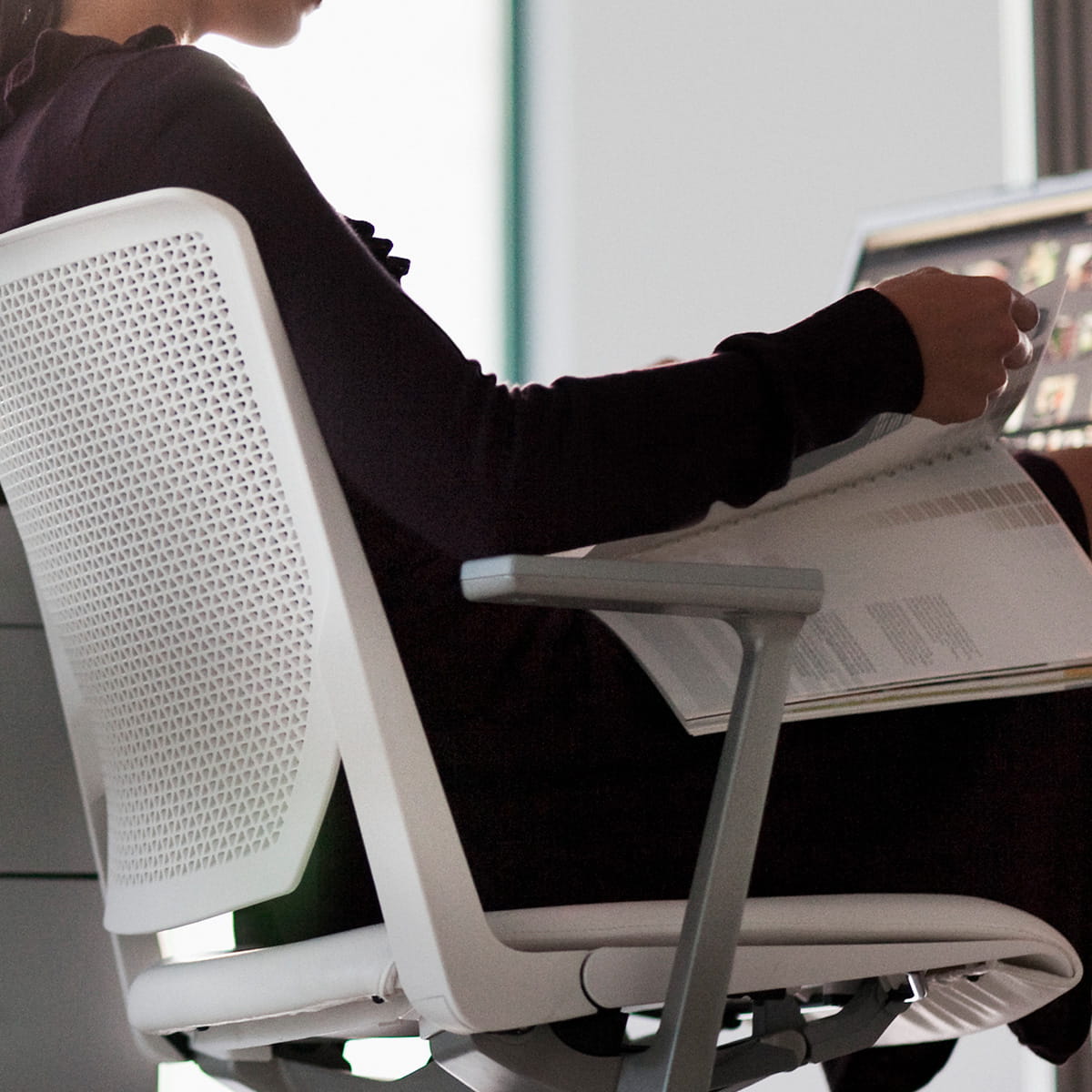 Employée de bureau assise au bureau en regardant les fichiers