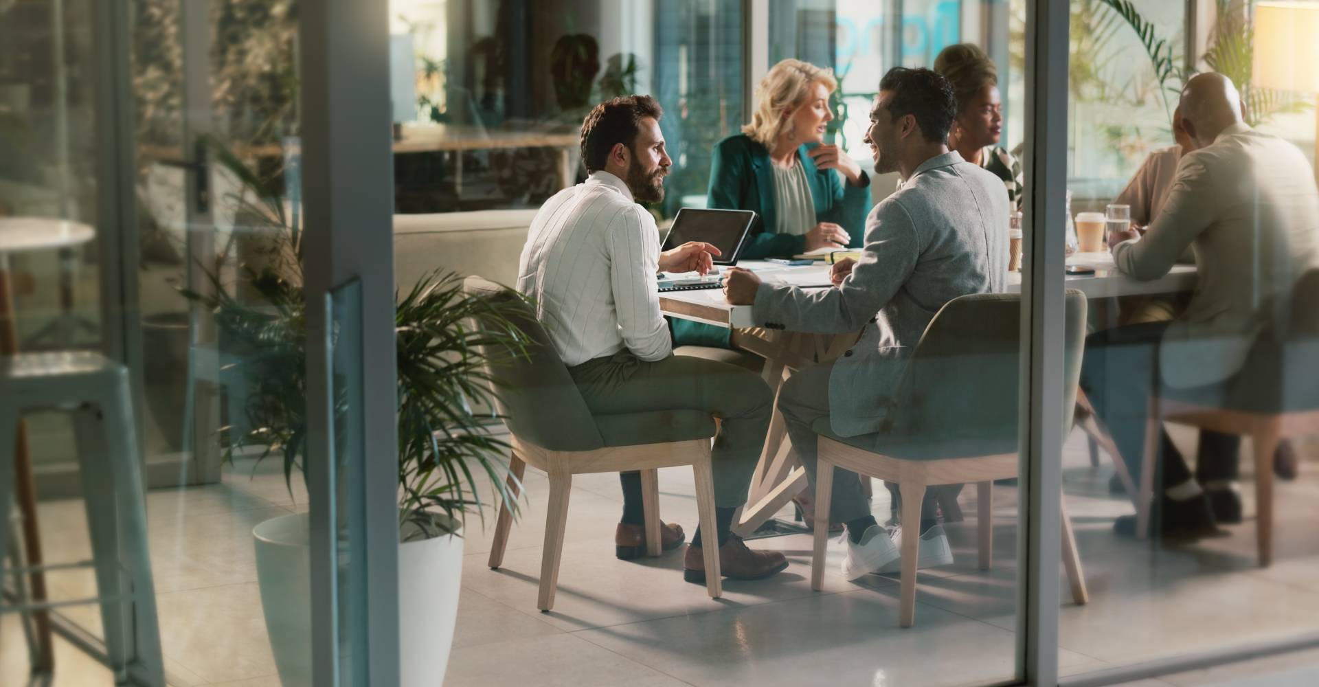 A business meeting being held in a glass office.